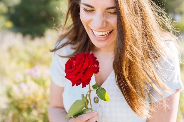 Smiley Frau posiert beim Halten Rose