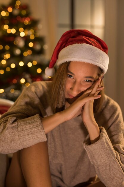 Smiley Frau posiert beim Tragen von Weihnachtsmütze