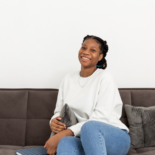 Smiley-Frau sitzt auf der Couch