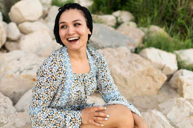 Smiley-Frau sitzt auf Felsen