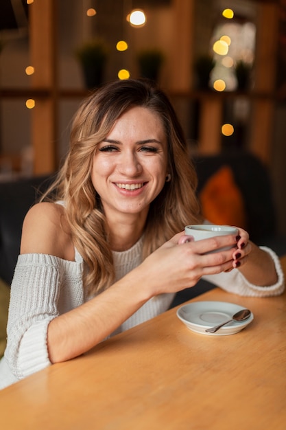 Kostenloses Foto smiley frau tasse kaffee zu trinken