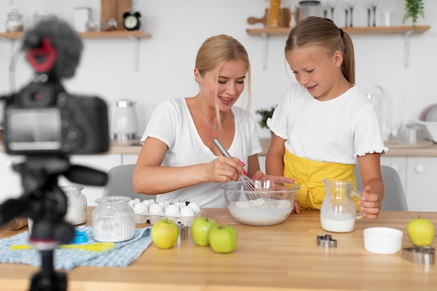 Kostenloses Foto smiley-frau und mädchen kochen