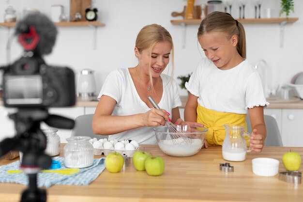 Smiley-Frau und Mädchen kochen