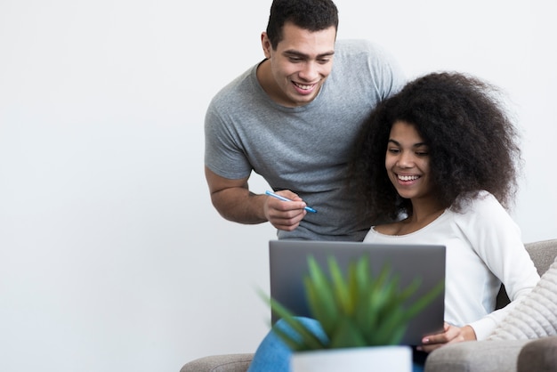 Smiley Frau und Mann arbeiten zusammen an einem Laptop