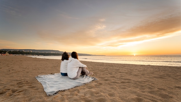 Kostenloses Foto smiley-frauen der seitenansicht am strand