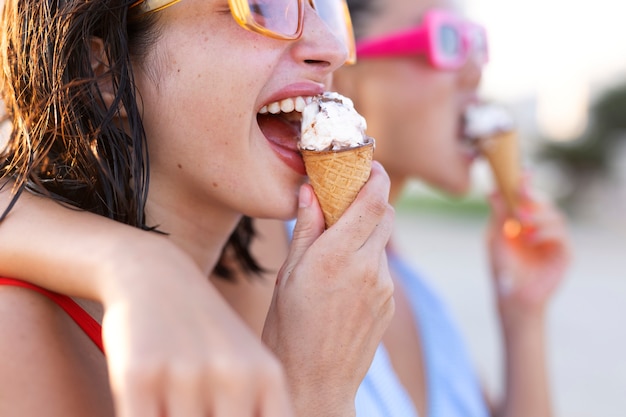 Kostenloses Foto smiley-frauen der seitenansicht, die eis essen