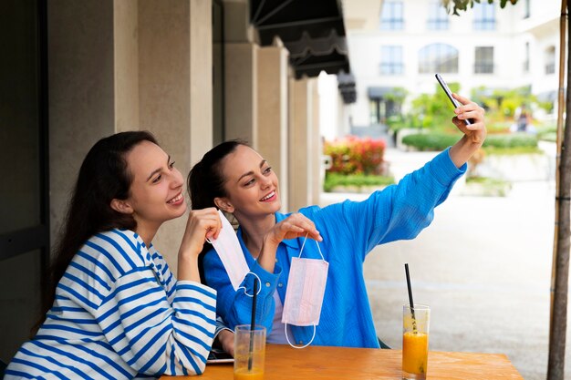 Smiley-Frauen der Seitenansicht, die selfie nehmen