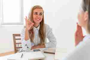 Kostenloses Foto smiley-frauen, die durch gebärdensprache kommunizieren