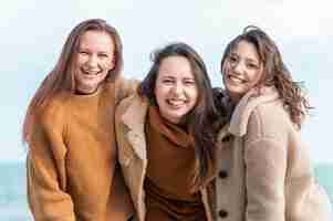 Kostenloses Foto smiley-frauen, die zusammen am meer aufwerfen