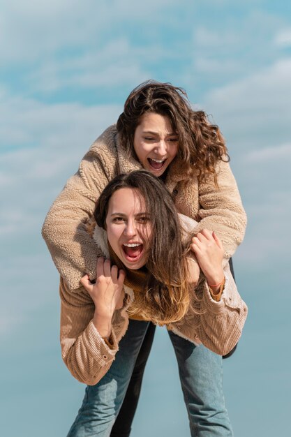 Smiley-Frauen, die zusammen draußen aufwerfen