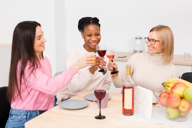 Smiley-Frauen jubeln mit einem Glas Wein