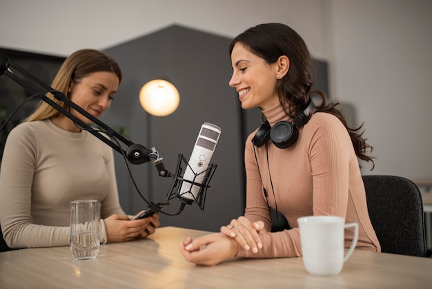 Kostenloses Foto smiley-frauen machen einen podcast im radio mit einem mikrofon