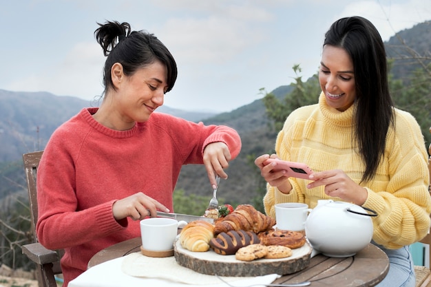 Smiley-Frauen mit mittlerer Aufnahme und Essen