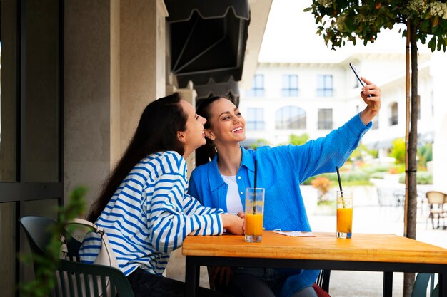 Smiley-Frauen mit Seitenansicht, die sich im Freien selbst machen