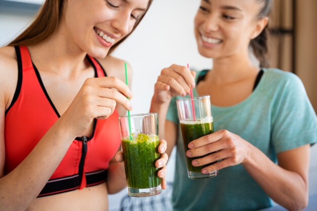 Smiley-Frauen mit Smoothie-Seitenansicht