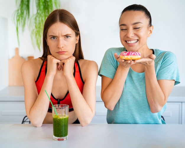 Kostenloses Foto smiley-frauen mit smoothie-vorderansicht