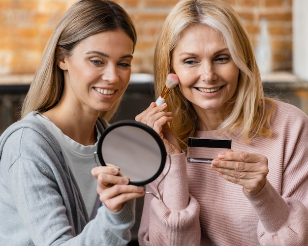 Kostenloses Foto smiley-frauen schminken sich zu hause