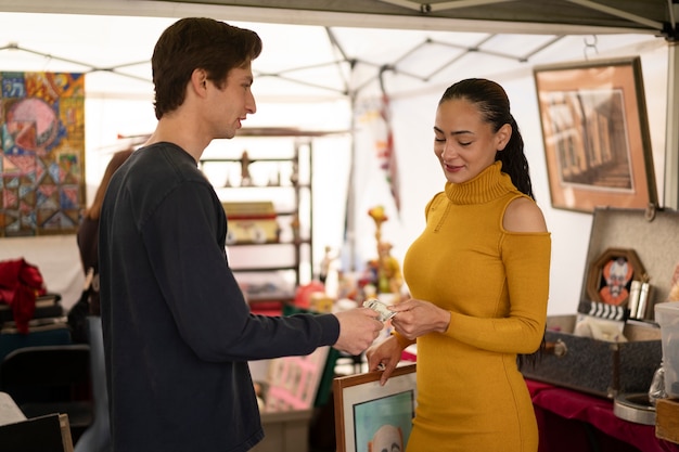 Kostenloses Foto smiley-freunde der seitenansicht auf dem flohmarkt