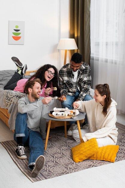 Smiley-Freunde mit vollem Schuss, die Sushi essen