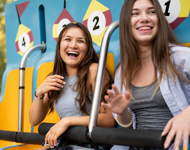 Smiley-Freundinnen auf der Fahrt im Vergnügungspark