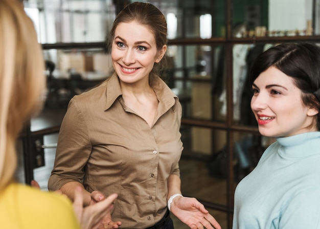 Smiley-Geschäftsfrauen diskutieren drinnen