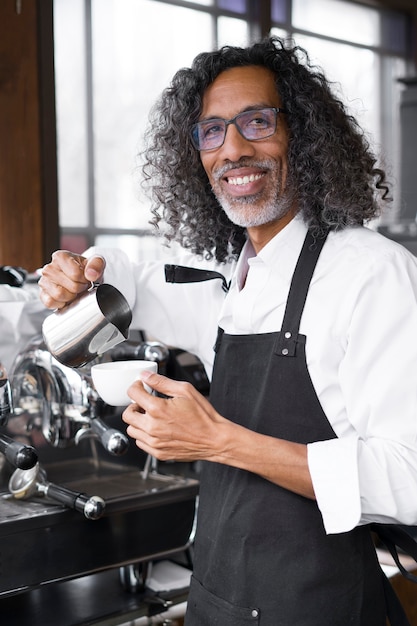 Smiley-Geschäftsinhaber der mittleren Aufnahme, der Kaffee kocht