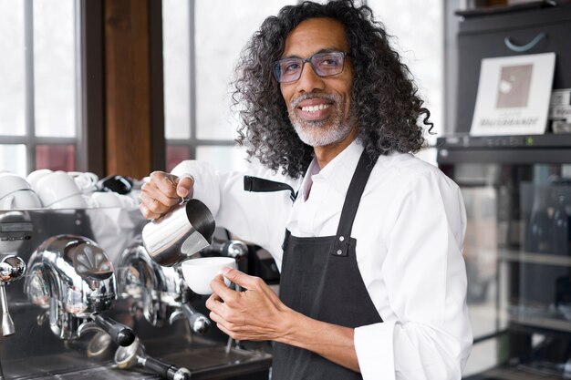 Smiley-Geschäftsinhaber der Seitenansicht, der Kaffee kocht