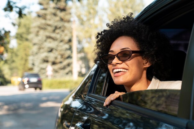 Smiley glückliche Frau mit Sonnenbrille in einem Auto