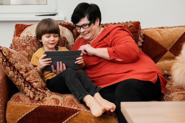 Smiley Großmutter spielt mit Enkel auf Tablette