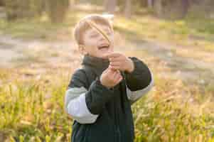 Kostenloses Foto smiley-junge, der im park spielt