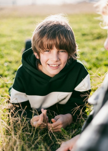 Kostenloses Foto smiley-junge mit seinem freund auf gras