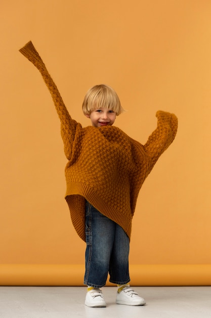 Kostenloses Foto smiley-kind der vorderansicht, das im studio aufwirft