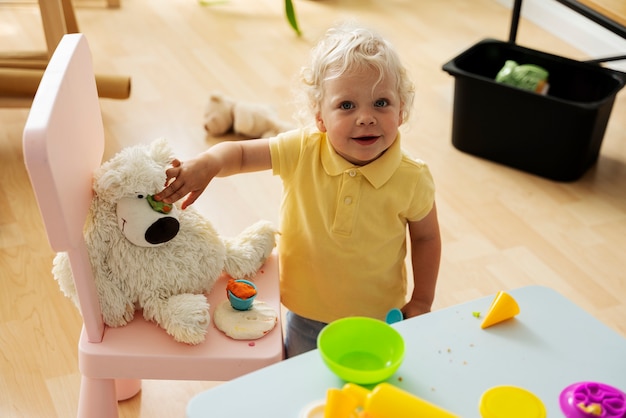 Smiley-Kind des hohen Winkels mit Spielzeug