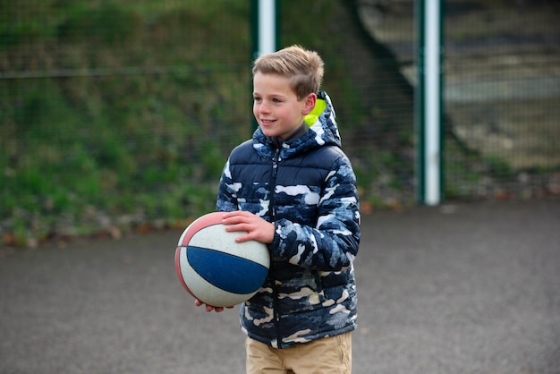 Smiley-Kind mit mittlerem Schuss, der Ball hält