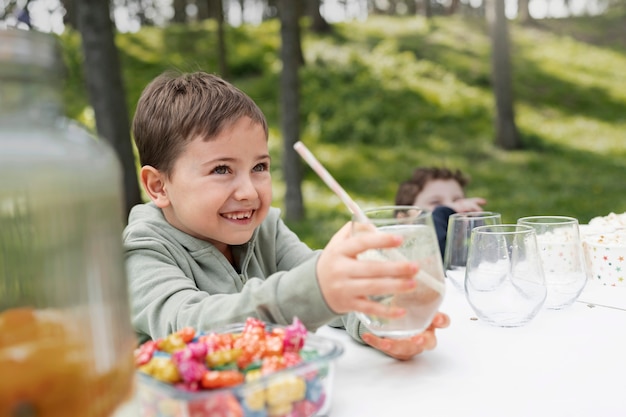 Kostenloses Foto smiley-kind mit mittlerer aufnahme und limonade