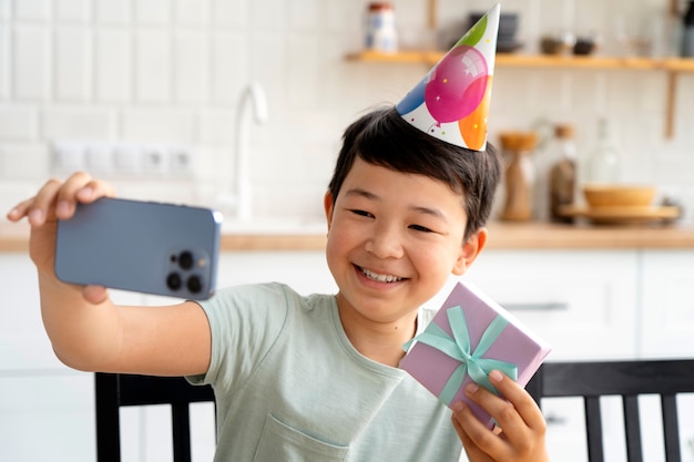 Smiley-Kind mit Seitenansicht, das Geburtstag feiert