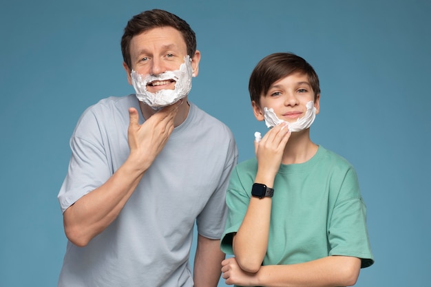 Smiley-Kind und Mann der Vorderansicht mit Rasierschaum