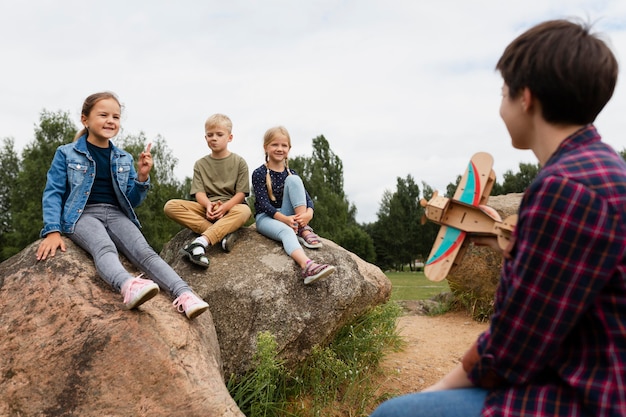 Smiley-Kinder mit mittlerer Aufnahme, die auf Felsen sitzen