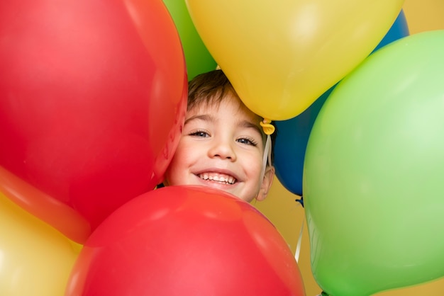 Kostenloses Foto smiley kleiner junge, der einen geburtstag feiert