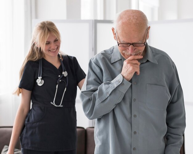 Smiley-Krankenschwester mit altem Mann in einem Pflegeheim