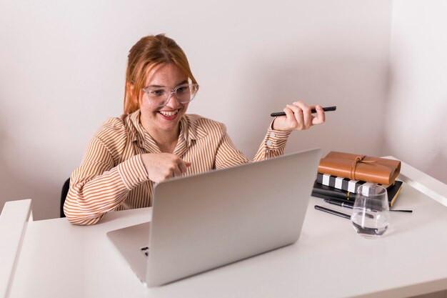 Smiley-Lehrerin, die Laptop während des Online-Unterrichts mit Schülern verwendet