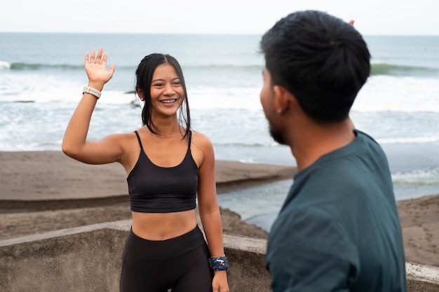 Kostenloses Foto smiley-leute der seitenansicht am strand