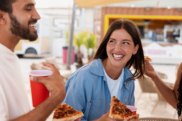 Smiley-Leute der Seitenansicht mit Pizza