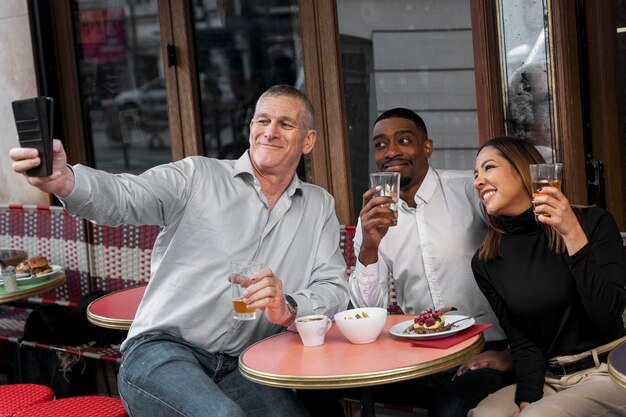 Smiley-Leute, die Selfie im Bistro machen, mittlerer Schuss