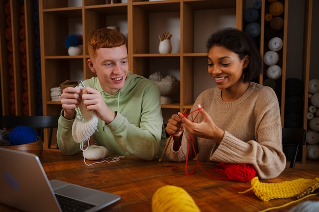 Kostenloses Foto smiley-leute mit mittlerer aufnahme, die zusammenstricken