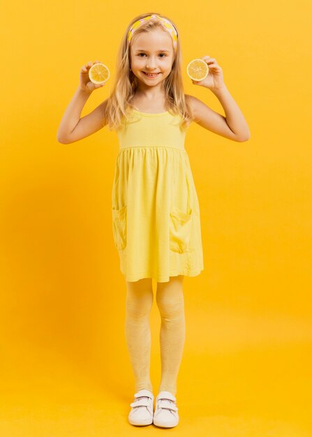 Smiley-Mädchen, das mit Zitronenscheiben aufwirft