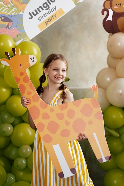 Smiley-Mädchen der Vorderansicht, das Giraffe hält