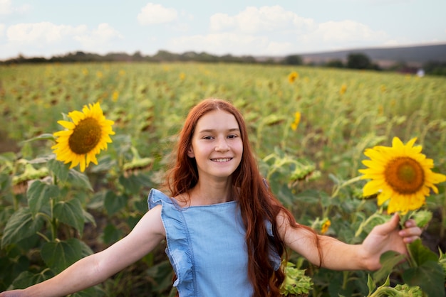 Smiley-Mädchen der Vorderansicht mit Sonnenblumen