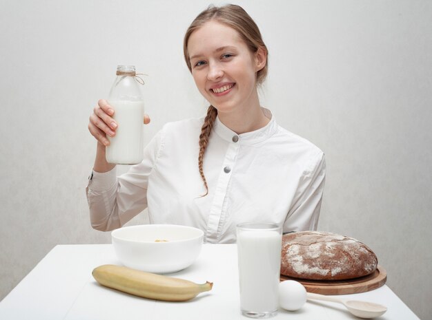 Smiley Mädchen hält eine Flasche Milch