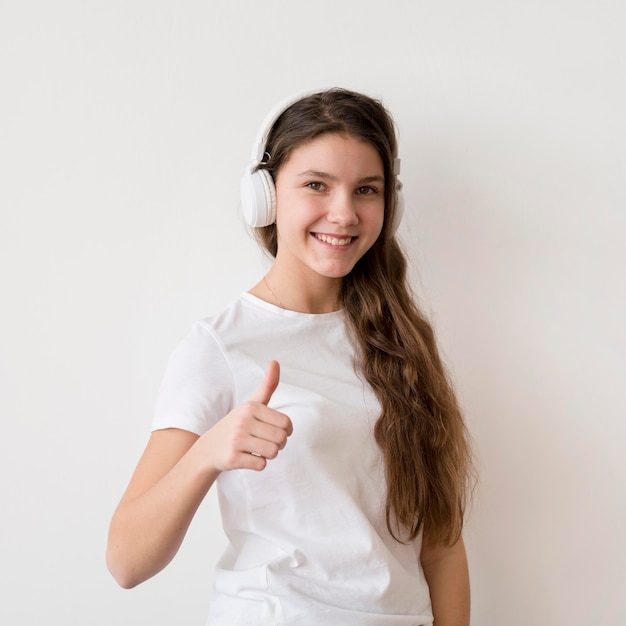 Smiley-Mädchen mit Kopfhörern, die ok Zeichen zeigen